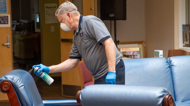 David Fiskum sprays down furniture with sanitizer at the Frank Bailey Senior Center last week during the county's deep cleaning and sanitizing of the building in preparation for the upcoming public reopening.