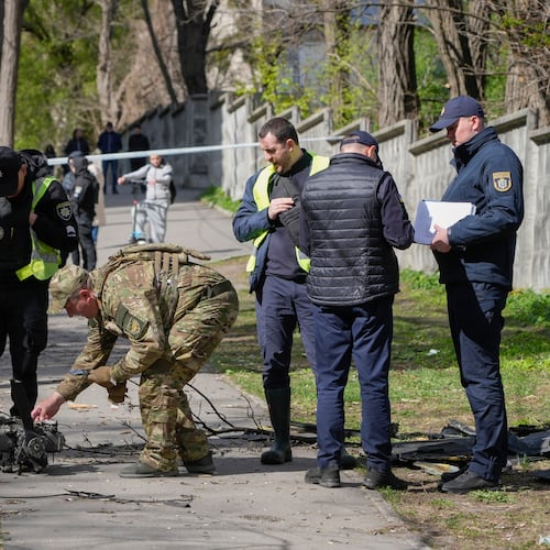 Police officers inspect fragments of a Russian drone after an air attack in Kyiv, Ukraine, Tuesday, April 28, 2026. (AP Photo/Efrem Lukatsky)