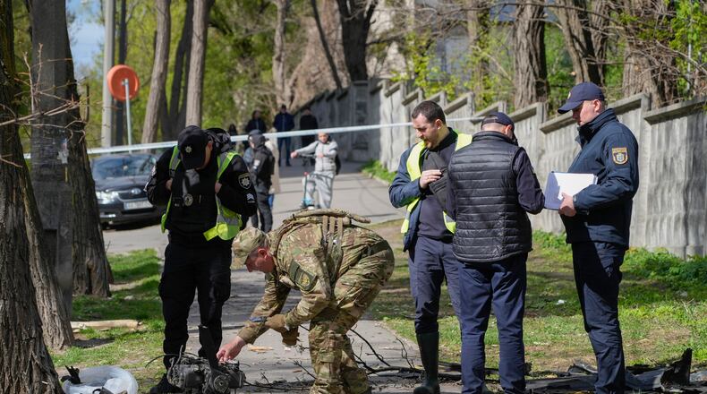 Police officers inspect fragments of a Russian drone after an air attack in Kyiv, Ukraine, Tuesday, April 28, 2026. (AP Photo/Efrem Lukatsky)