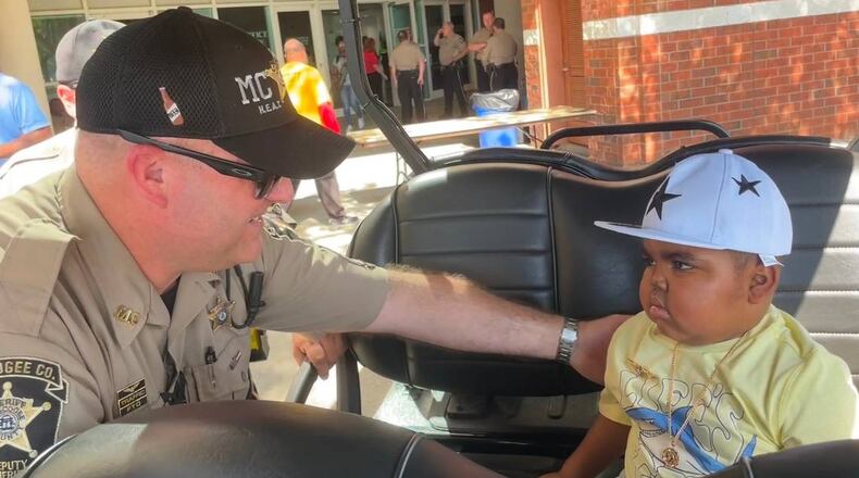 4-year-old Armon is given a sheriff pin by one of the Muscogee County sheriff's deputies. (Photo Courtesy of Bea Lunardini)
