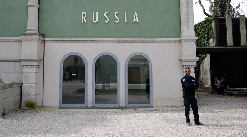 FILE - A private security officer stands next to a closed Russia's pavilion at the 59th Biennale of Arts exhibition in Venice, Italy, Tuesday, April 19, 2022. (AP Photo/Antonio Calanni, File)