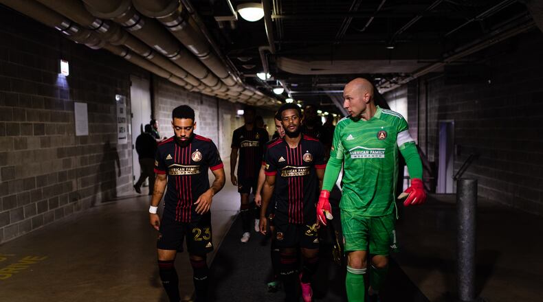 Atlanta United goalkeeper Brad Guzan #1, midfielder Jake Mulraney #23, and midfielder Mo Adams #29 walk out onto the pitch before the match against Chicago Fire FC at Soldier Field in Chicago, Illinois on Saturday July 3, 2021. (Photo by Jacob Gonzalez/Atlanta United)