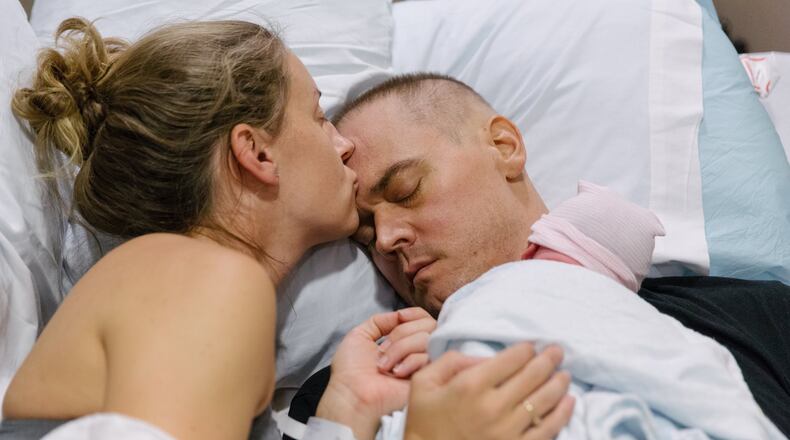 Jenna, Josh and baby Reilly Buehler together an hour after delivery at Piedmont Hospital in Atlanta. Josh’s neuro-oncologist, Dr. Erin Dunbar, assisted in coordinating a bed for Josh in the delivery room. Josh had undergone treatment for glioblastoma, the most common and most aggressive form of brain cancer. He recently passed away. This is part of a photo documentary by Jennifer Keenan Giliberto, a professional photographer. CONTRIBUTED BY JENNIFER KEENAN GILIBERTO
