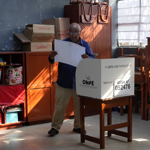 A voter looks at a ballot before marking his candidates during general elections in Lima, Peru, on Sunday, April 12, 2026. (AP Photo/Martin Mejia)