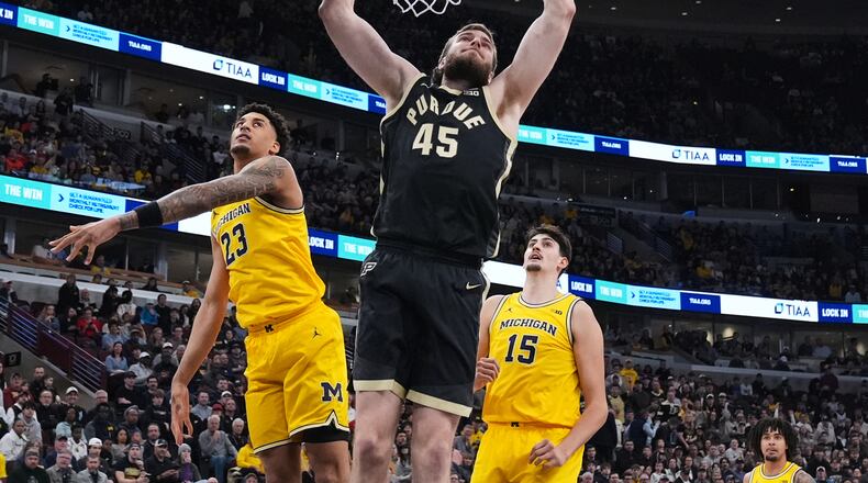 Purdue center Oscar Cluff (45) dunks past Michigan forward Yaxel Lendeborg (23) during the first half of an NCAA college basketball game in the championship of the Big 10 Conference tournament, Sunday, March 15, 2026, in Chicago. (AP Photo/Nam Y. Huh)