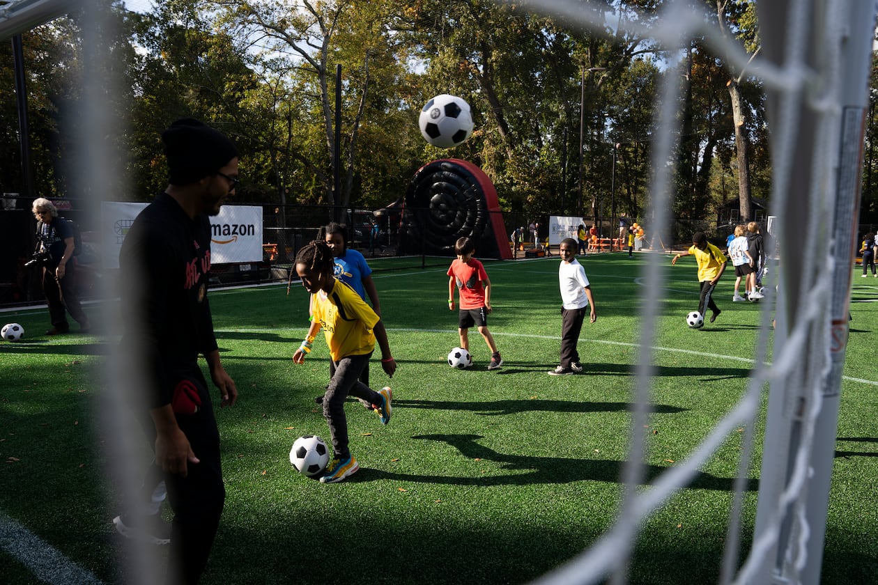Kids play on Soccer in the Streets' field at the East Lake MARTA Station in Atlanta on Oct, 27, 2023. Sports marketing executive Vince Thompson is buying tickets for a small number of youngsters from the program and their chaperones to attend a World Cup game June 24. (Olivia Bowdoin for the AJC)