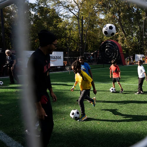 Kids play on Soccer in the Streets' field at the East Lake MARTA Station in Atlanta on Oct, 27, 2023. Sports marketing executive Vince Thompson is buying tickets for a small number of youngsters from the program and their chaperones to attend a World Cup game June 24. (Olivia Bowdoin for the AJC)