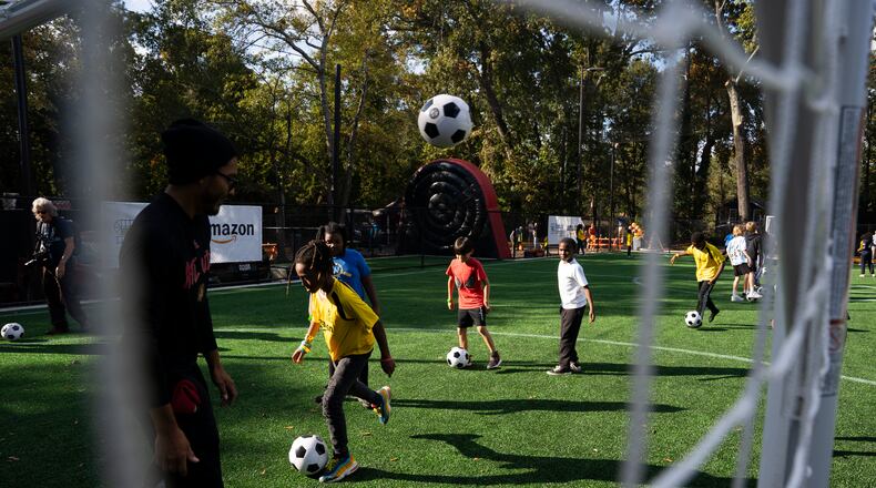 Kids play on Soccer in the Streets' field at the East Lake MARTA Station in Atlanta on Oct, 27, 2023. Sports marketing executive Vince Thompson is buying tickets for a small number of youngsters from the program and their chaperones to attend a World Cup game June 24. (Olivia Bowdoin for the AJC)