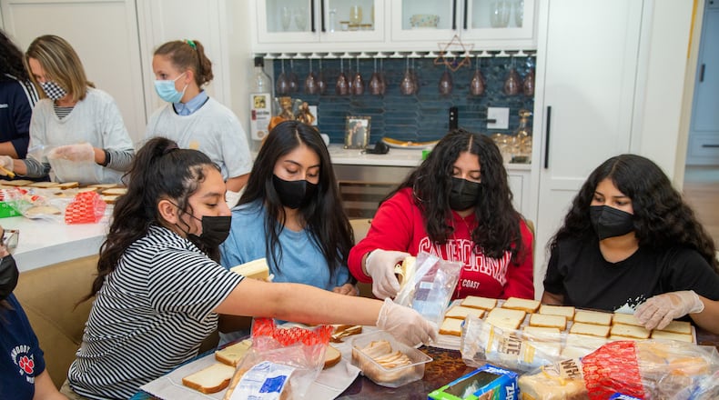 Geovanna Rodas (from left), Mary Avecillas, Victoria Cardenas and Raquel Espinoza work together at Marcy Louza's Dunwoody home making sandwiches for The Sandwich Project. Two ladies from Dunwoody started making sandwiches for the homeless during the pandemic and this project has expanded into a weekly community service project involving thousands of volunteers all over the metro area. Every week, The Sandwich Project gives away approximately 4,000 to 6,000 sandwiches, plus snacks and fruit to nonprofits for distribution. PHIL SKINNER FOR THE ATLANTA JOURNAL-CONSTITUTION.