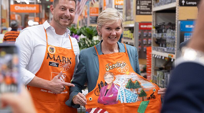 Buckhead Home Depot manager Mark Cox takes a photo with U.S. Secretary of Energy Jessica Granholm wearing a custom Home Depot apron designed by an employee at the Cumberland store on Wednesday, June 28, 2023. Secretary Granholm is visiting Georgia to discuss clean energy initiatives. (Natrice Miller/ Natrice.miller@ajc.com)