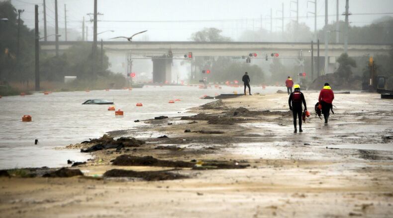 Members of Savannah Fire Rescue check a vehicle floating on flooded President Street after Hurricane Matthew caused flooding along the east coast of Georgia, Saturday, Oct. 8, 2016, in Savannah, Ga. A woman was rescued from the car by another unit closer to the scene. (AP Photo/Stephen B. Morton)