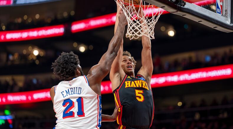 Atlanta Hawks guard Dyson Daniels dunks on Philadelphia 76ers center/forward Joel Embiid during the first half of Sunday's game. (Erik Rank/AP)