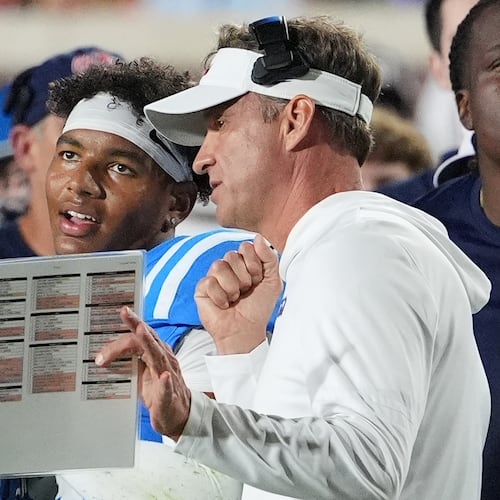 FILE - Mississippi head coach Lane Kiffin, center right, confers with quarterback Trinidad Chambliss, center left, during an NCAA college football game against Florida, Nov. 15, 2025, in Oxford, Miss. (AP Photo/Rogelio V. Solis, File)