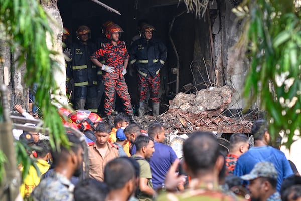Firemen look for the survivors after a Bangladesh Air Force training aircraft that crashed onto a school campus shortly after takeoff in Dhaka, Bangladesh, Monday, July 21, 2025. (AP Photo/Mahmud Hossain Opu)