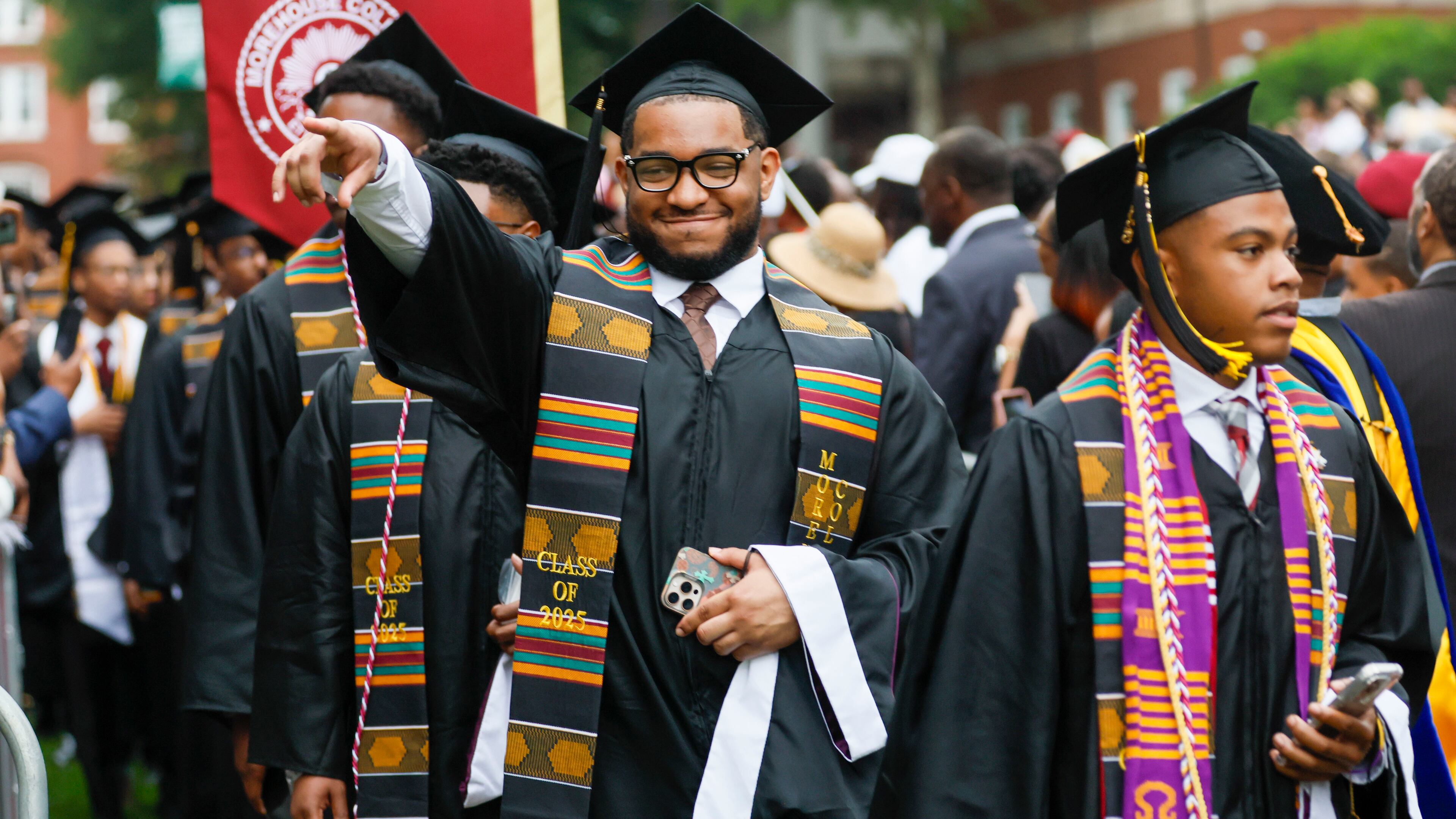 A graduate reacts to family members as he enters the ceremony during Morehouse College's 141st Commencement Ceremony on Sunday, May 18, 2025. The school has seen a spike in interest in recent years, receiving a record-high number of applications.  
(Miguel Martinez/ AJC)