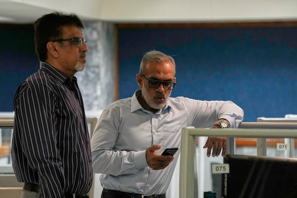 Stock brokers discuss the situation at the Pakistan Stock Exchange (PSE), after trading suspended for an hour following a 5% drop in in its main index, in Karachi, Pakistan, Monday, April 7, 2025. (AP Photo/Fareed Khan)