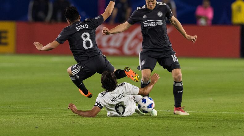 Atlanta United's Jeff Larentowicz and Ezequiel Barco tackle an L.A. Galaxy player during their game on Saturday, April 21, 2018 in Carson, Calif. (Atlanta United)