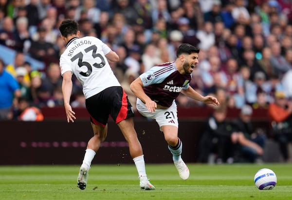 Fulham's Antonee Robinson, left, and Aston Villa's Marco Asensio battle for the ball during the English Premier League soccer match between Aston Villa and Fulham at Villa Park, Birmingham, England, Saturday, May 3, 2025. (Nick Potts/PA via AP)