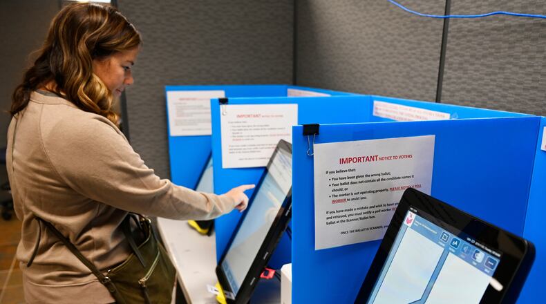 FILE- Courtney Parker votes on a new voting machine, in Dallas, Ga., Nov. 5, 2019. (AP Photo/Mike Stewart, File)