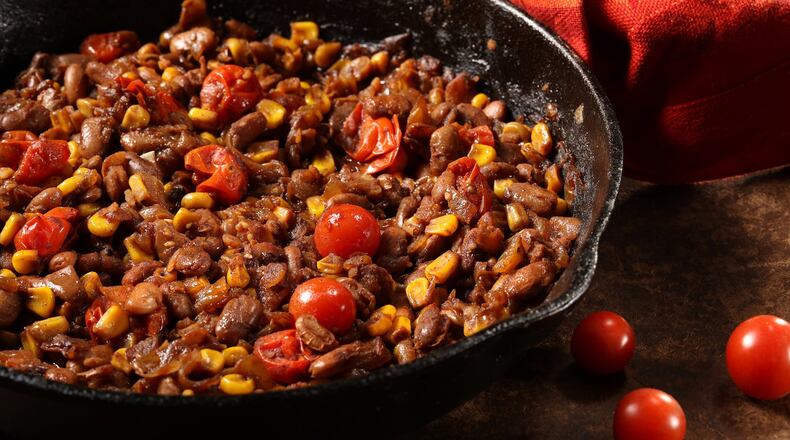 Beans are cooked with garlic, tomatoes, corn adn chile powder, all of it doused with a generous pour of a malty beer. (Food styling by Lisa Schumacher) (Abel Uribe/Chicago Tribune/TNS)