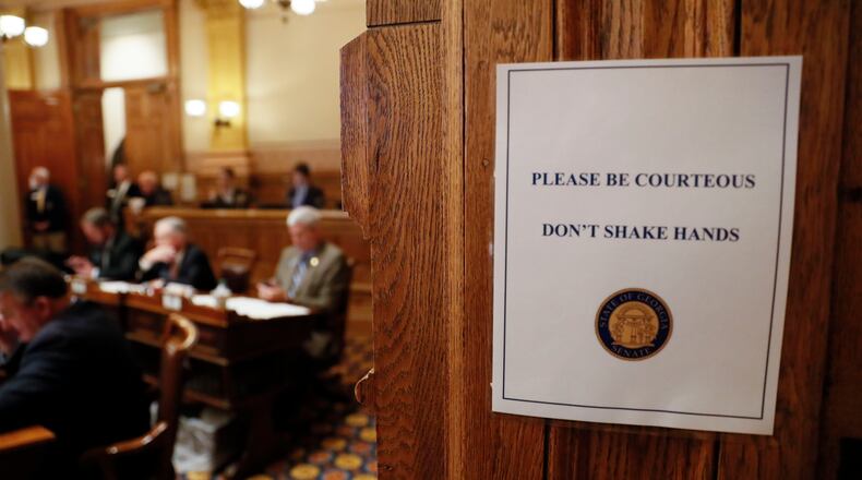 Signs in the senate chamber say "Don't shake hands". Georgia lawmakers gathered in an extraordinary special session on Monday and voted to grant Gov. Brian Kemp sweeping new powers to respond to the coronavirus pandemic. It's the first time in state history a governor has declared a public health emergency, and Kemp cast it as essential to deploy all available resources to contain a disease that's sickened dozens of Georgians and has killed one. Bob Andres / robert.andres@ajc.com