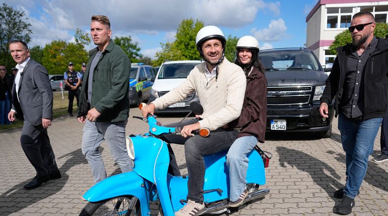 Ulrich Siegmund, top candidate for the "Alternative for Germany" (AfD) party and his wife Julia leaving a polling station on a small Schwalbe motorcycle after voting during the Saxony-Anhalt state elections in Tangermuende, eastern Germany, Sunday, Sept. 6, 2026. (AP Photo/Matthias Schrader)