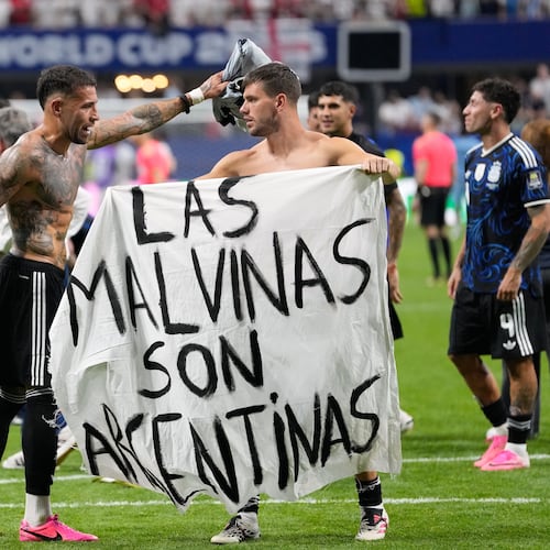 Argentina's Giovani Lo Celso holds a banner with the words "The Malvinas are Argentine", referring to the Falkland Islands, while teammate Argentina's Nicolas Otamendi gestures to him, at the end of the World Cup semifinal soccer match between England and Argentina in Atlanta, Wednesday, July 15, 2026. (AP Photo/Rebecca Blackwell)