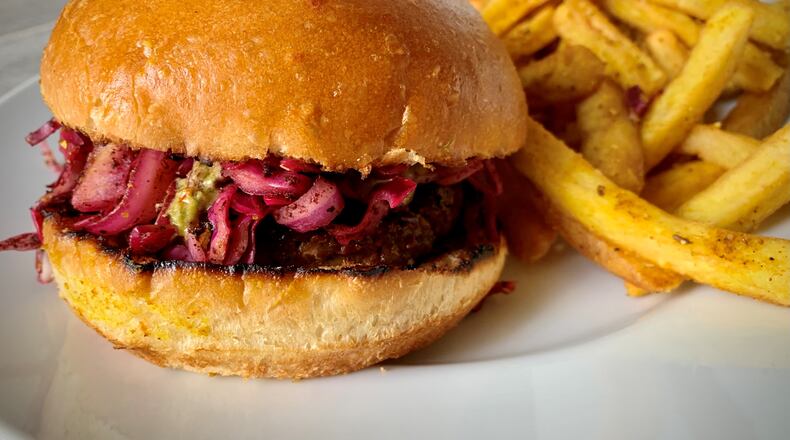 The spiced lamb burger with fries is available from Rina, an Israeli restaurant in Atlanta's Old Fourth Ward. Henri Hollis/henri.hollis@ajc.com