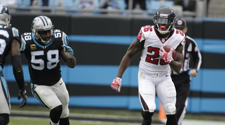 Falcons’ Tevin Coleman runs past the Panthers’ Thomas Davis in the second half of an NFL football game in Charlotte, N.C., Saturday, Dec. 24, 2016. (AP Photo/Bob Leverone)