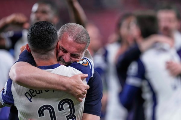 Tottenham's head coach Ange Postecoglou celebrates with Tottenham's Pedro Porro after the Europa League final soccer match between Tottenham Hotspur and Manchester United at the San Mames Stadium in Bilbao, Spain, Wednesday, May 21, 2025. (AP Photo/Jose Breton)
