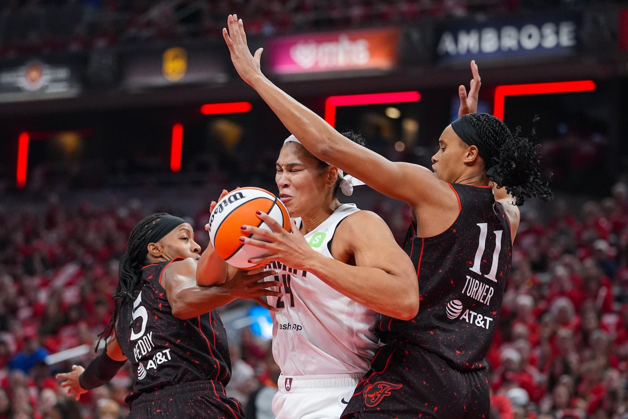 Atlanta Dream forward Brionna Jones (24) cuts between Indiana Fever guard Shey Peddy (5) and forward Brianna Turner (11) in the first half of a WNBA basketball playoff game in Indianapolis, Tuesday, Sept. 16, 2025. (AP Photo/Michael Conroy)