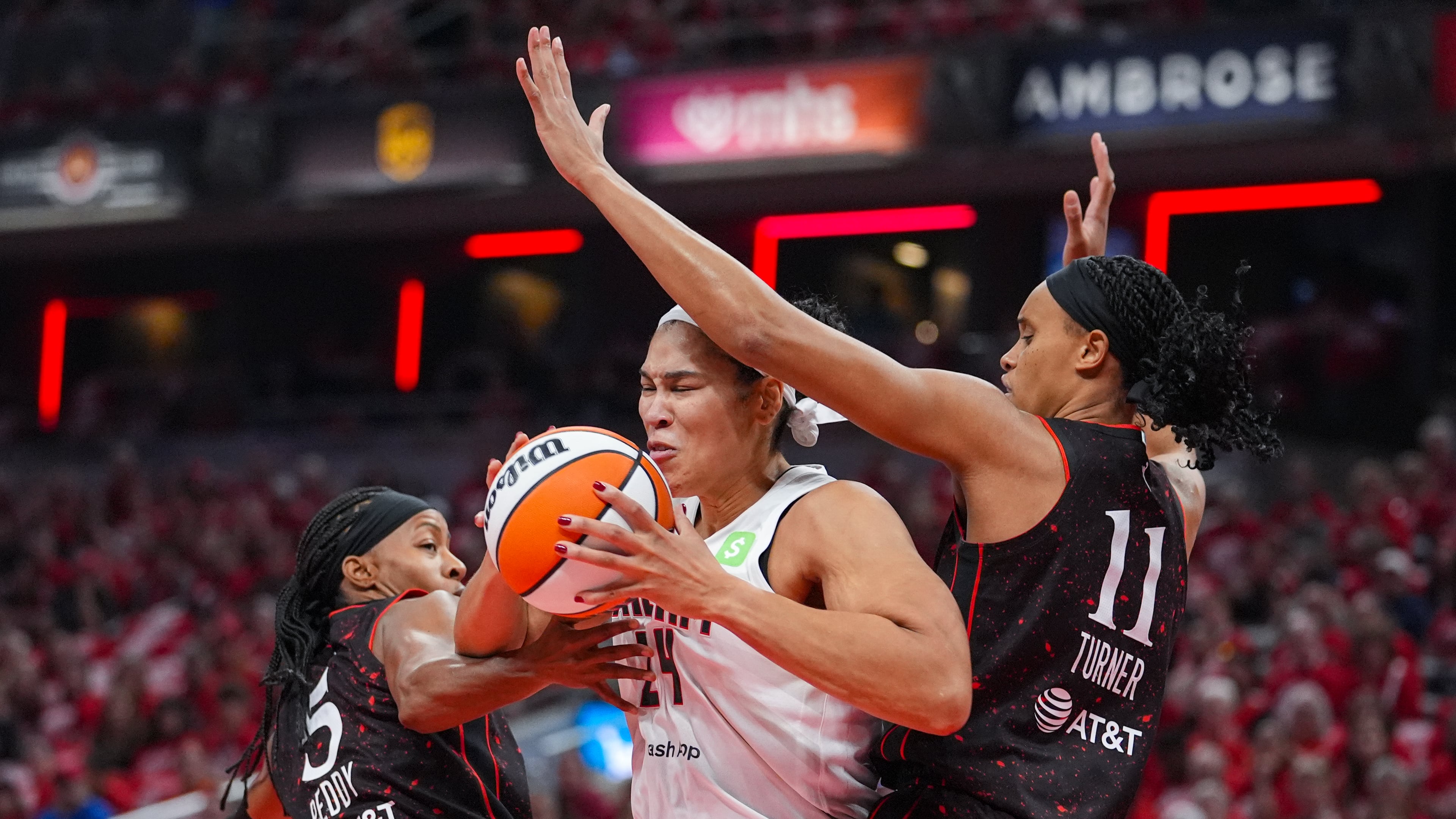Atlanta Dream forward Brionna Jones (24) cuts between Indiana Fever guard Shey Peddy (5) and forward Brianna Turner (11) in the first half of a WNBA basketball playoff game in Indianapolis, Tuesday, Sept. 16, 2025. (AP Photo/Michael Conroy)