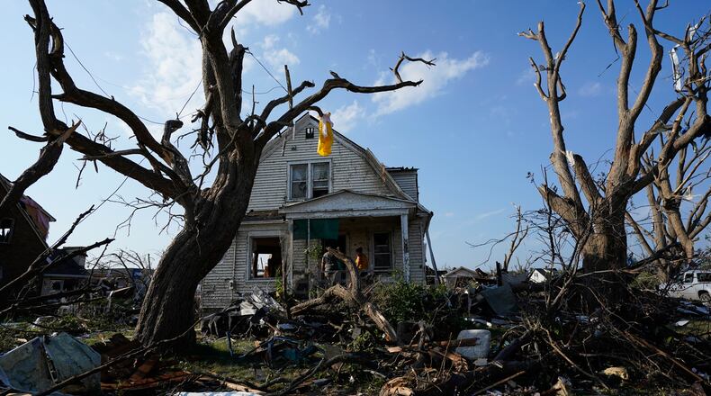 Debris is seen in front of a damaged house after a tornado struck Monday, July 27, 2026, in Menasha, Wis. (AP Photo/Kayla Wolf)