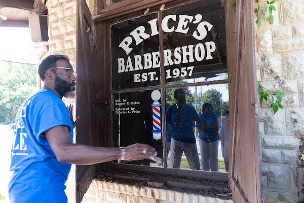 Larry Brady Evans closes the shutters on the former Price’s Barbershop on Wednesday, July 9, 2025, in College Park, where PHOAA plans to create a museum for the One Square Mile community. Harvard Avenue, where the building sits, was once a thriving main street for the African American community before much of it was destroyed to make way for airport expansion. (Ben Gray for The Atlanta Journal-Constitution)