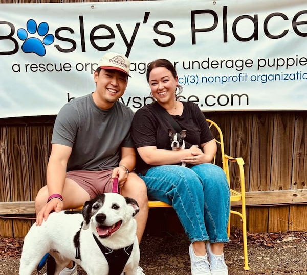 Woodstock couple Stephen Yokoi and Olivia Cervi on the day they first met puppy RuPaw (renamed Beanie), sitting in Olivia's lap in August 2025. They already own Oreo. (Courtesy)