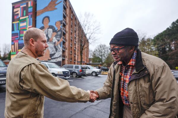 Chastain “Chaz” Clark chats with Legacy at East Lake resident Jessie Ellis Jr. near the mural he painted on Friday, Dec. 5, 2025. (Natrice Miller/AJC)