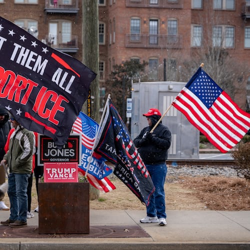 Pro-ICE demonstrators hold flags in support of ICE deportations along Main Street in downtown Woodstock, Ga., on Saturday, Jan. 31, 2026. (Ben Hendren for the AJC)