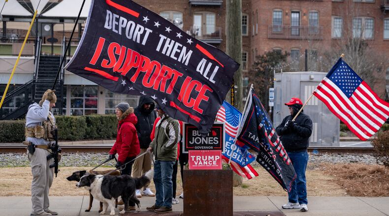 Pro-ICE demonstrators hold flags in support of ICE deportations along Main Street in downtown Woodstock, Ga., on Saturday, Jan. 31, 2026. (Ben Hendren for the AJC)