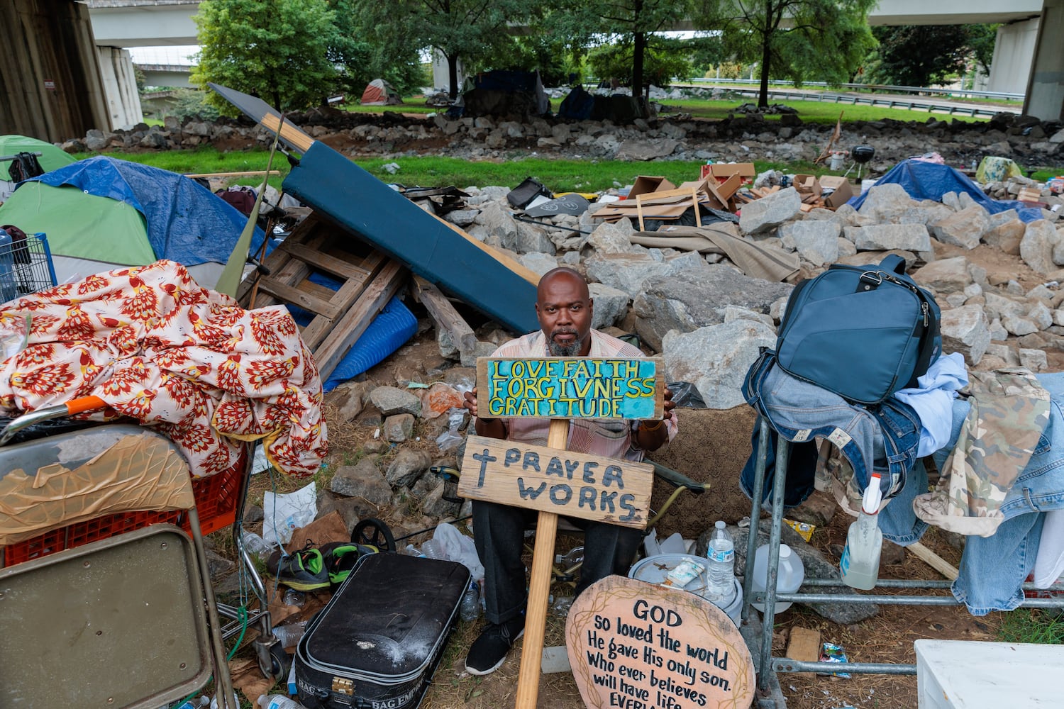 Thomas Lecky, 41, poses for a portrait with his artwork at a homeless encampment in downtown Atlanta on Thursday, August 25, 2022. The city and the nonprofit Partners for HOME plan to shut down the encampment before Labor Day and find housing for the residents. Making art “centers me and reminds me of my purpose,” says Lecky. “If I didn’t have occupations and things that I do out here, I wouldn’t be able to survive.” (Arvin Temkar / arvin.temkar@ajc.com)