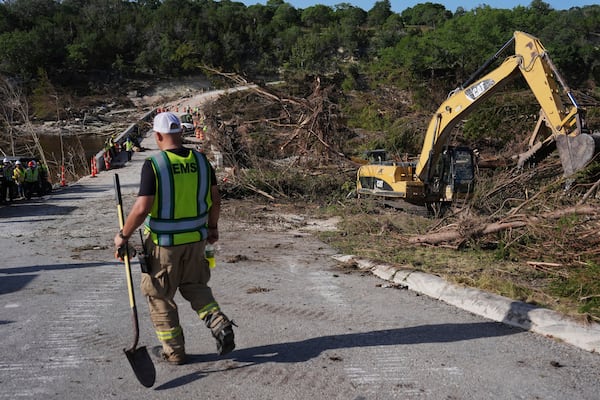 Crews work on the Cade Loop Bridge to clear debris following flooding, Thursday, July 10, 2025, in Ingram, Texas. (AP Photo/Joshua A. Bickel)