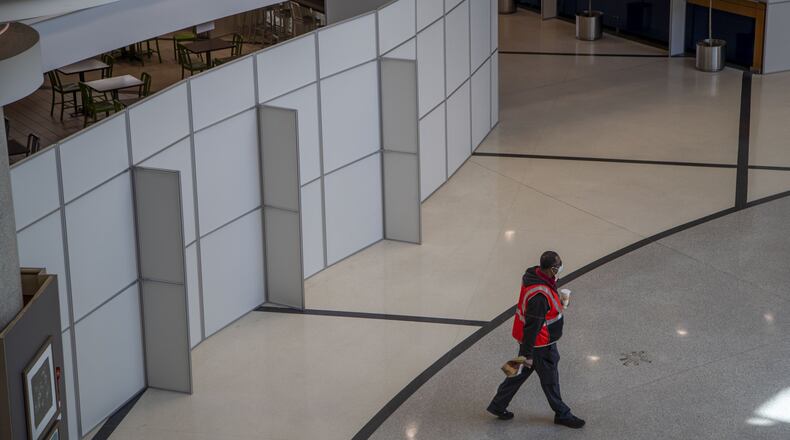 After ordering from Burger King, one of three eateries open in the domestic terminal lobby, an individual carries his food away from the gated dining area at Atlanta’s Hartsfield-Jackson International Airport, Tuesday, April 28, 2020. (ALYSSA POINTER / ALYSSA.POINTER@AJC.COM)