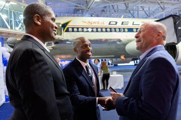 (L-R) Delta first officers Sean Allen and Jarred Lundy speak with Chief Pilot Brian Cink during a Delta pilot graduation ceremony at the Delta Flight Museum in Hapeville on Wednesday, June 11, 2025. The ceremony features a COVID-era tradition of older pilots passing on their wing pins to younger pilots. Allen passed on his wings to Lundy. (Arvin Temkar / AJC)