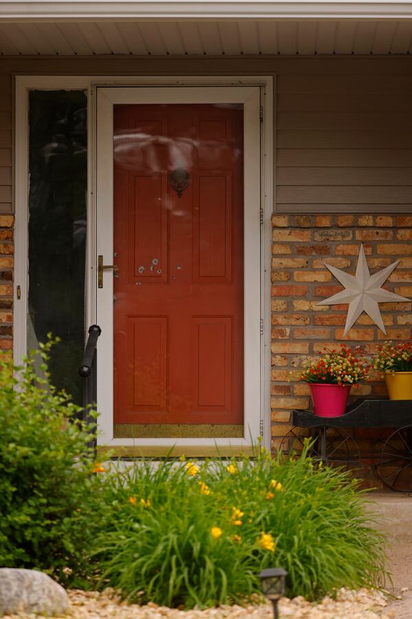 Bullet holes mark the front door of the house of Minnesota state Sen. John Hoffman and his wife who were shot earlier in the day, Saturday, June 14, 2025, in Champlin, Minn. (AP Photo/Bruce Kluckhohn)