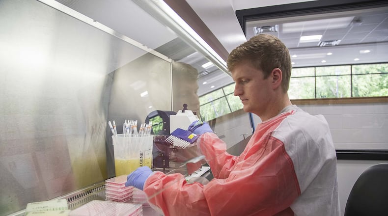 University of Georgia fourth-year graduate student Beau Reneer wears protective garb as he works with the flu virus at the University of Georgia College of Veterinary Medicine building in Athens. Reneer is one of the lab staff that has been given the opportunity to work with the COVID-19 virus to look for a vaccine. Researchers at Georgia’s universities and medical schools are looking into treatment and vaccines for COVID-19. ALYSSA POINTER / ALYSSA.POINTER@AJC.COM