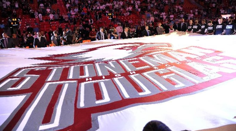 A large banner in memory of the victims of the Marjory Stoneman Douglas High School shooting is unfurled before an NBA basketball game in Miami on Saturday, Feb. 24, 2018, between the Miami Heat and the Memphis Grizzlies. (AP Photo/Gaston De Cardenas)