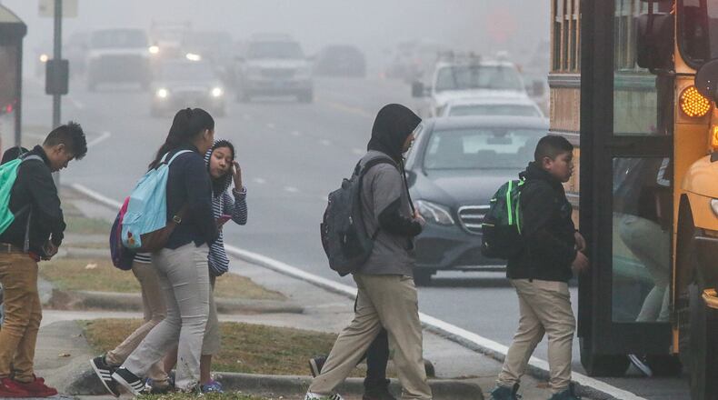 School children deal with fog getting on the bus onSchool children get on the bus on S. Cobb Dr. near Pat Mell Road in the fog