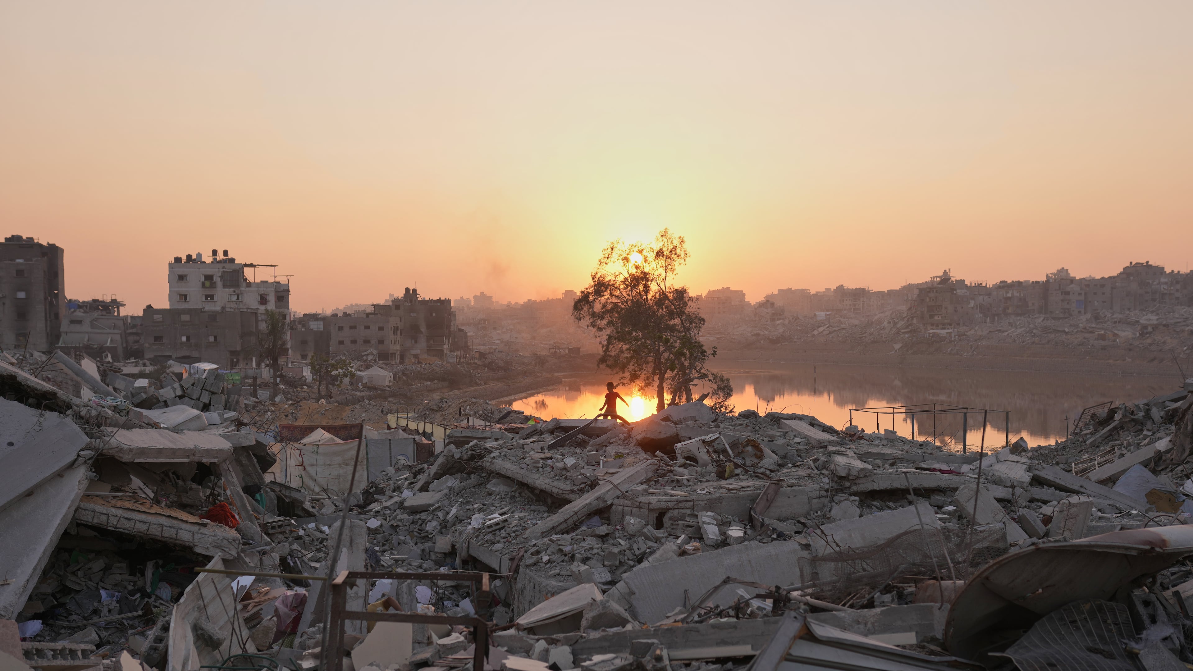 A Palestinian child walks through the destruction caused by the Israeli air and ground offensive in Sheikh Radwan neighborhood in Gaza City, Monday, Nov. 10, 2025. (AP Photo/Jehad Alshrafi)