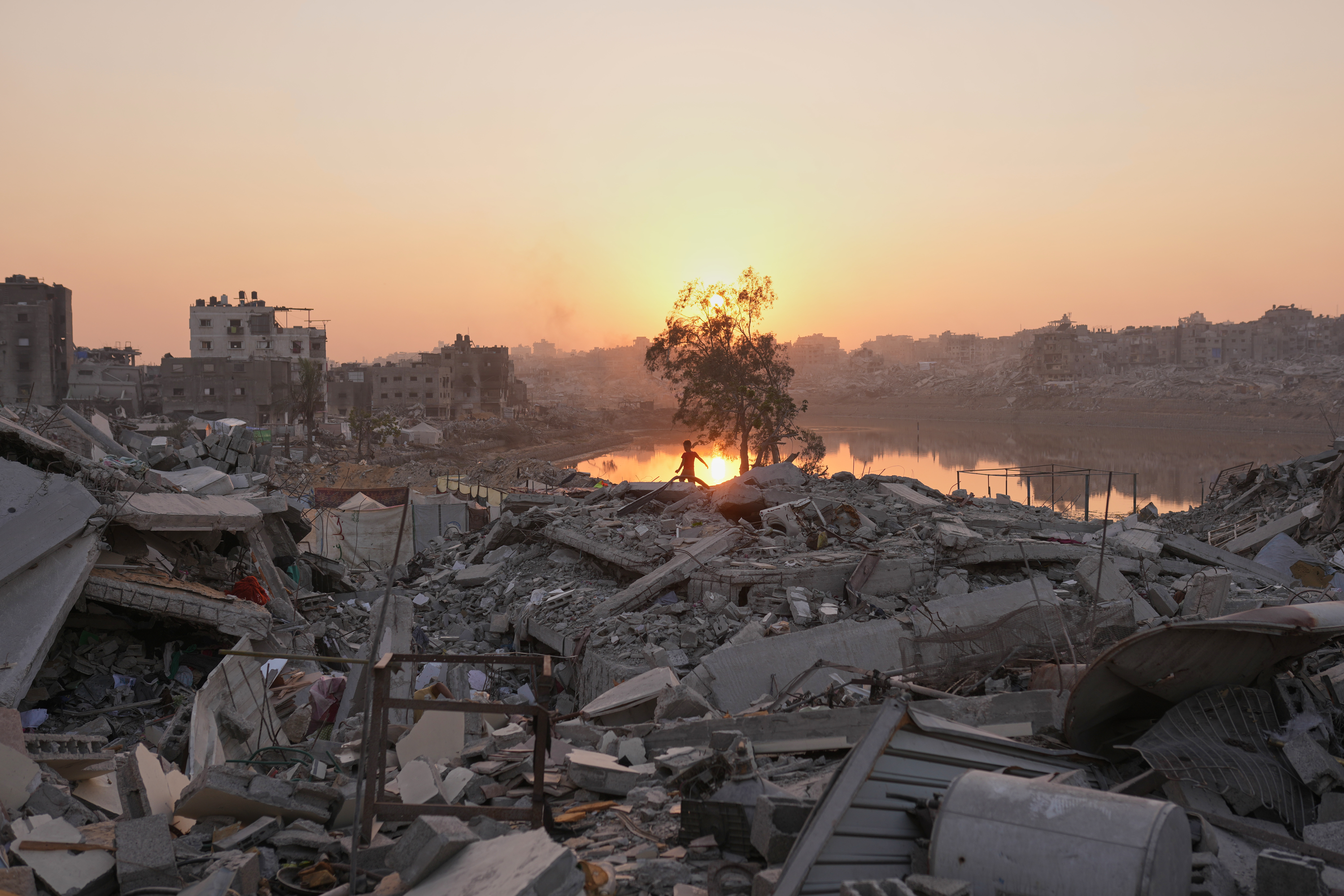 A Palestinian child walks through the destruction caused by the Israeli air and ground offensive in Sheikh Radwan neighborhood in Gaza City, Monday, Nov. 10, 2025. (AP Photo/Jehad Alshrafi)