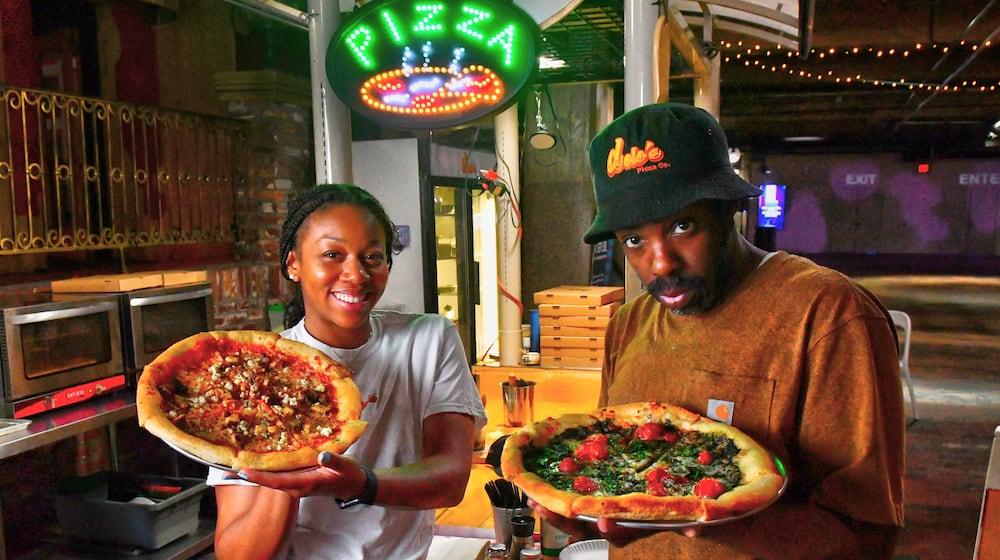 Dolo's Pizza owners Alyson Williams (left) and Yusef Walker show two of their creations at their pop-up pizzeria in Underground Atlanta. Chris Hunt for The Atlanta Journal-Constitution