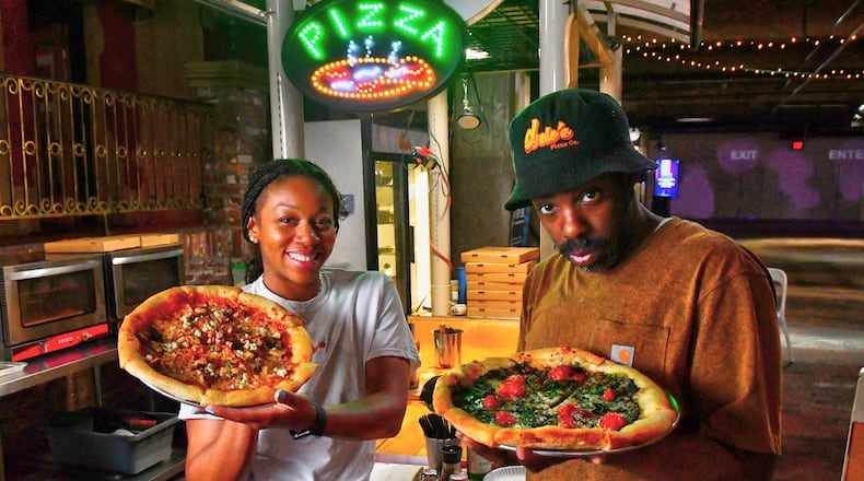 Dolo's Pizza owners Alyson Williams (left) and Yusef Walker show two of their creations at their pop-up pizzeria in Underground Atlanta. Chris Hunt for The Atlanta Journal-Constitution